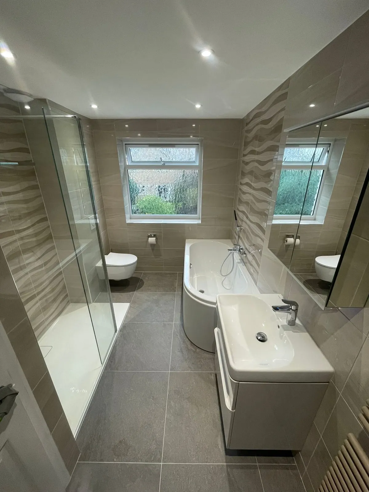 Walk-in shower with a level-access tray and glass screen, fitted by Venus in a Leighton Buzzard bathroom